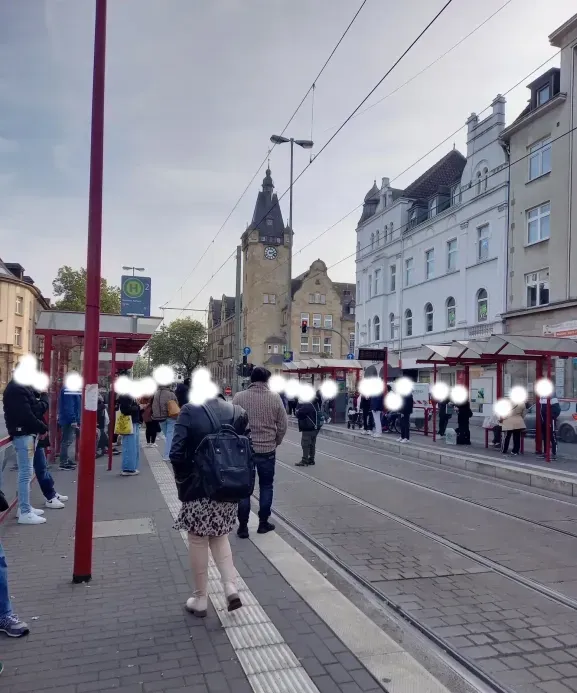 Menschen warten auf verspätete Straßenbahn und stehen auf den Schienen