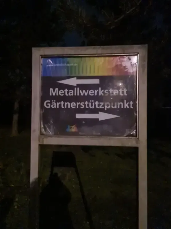 Hinweisschild im Landschaftspark bei Nacht