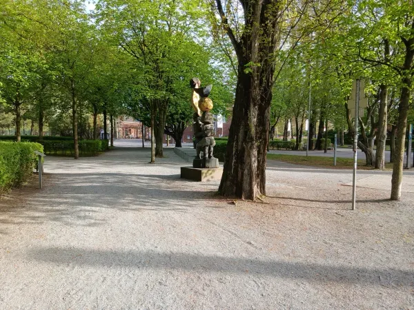 Weg mit Bäumen und Skulptur im Landschaftspark