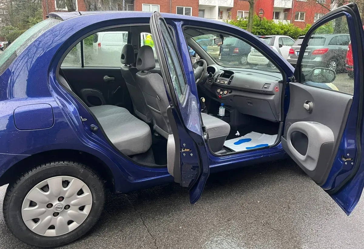 Nissan Micra Blau 5 Türer Baujahr 2007  Beifahrerseite Türen Stehen offen.