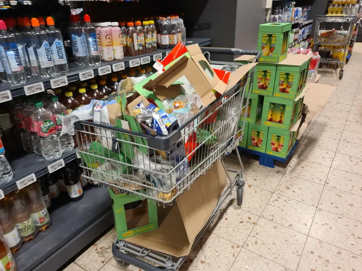 Einkaufswagen voller Pappe steht im Gang des REWE Duisburg