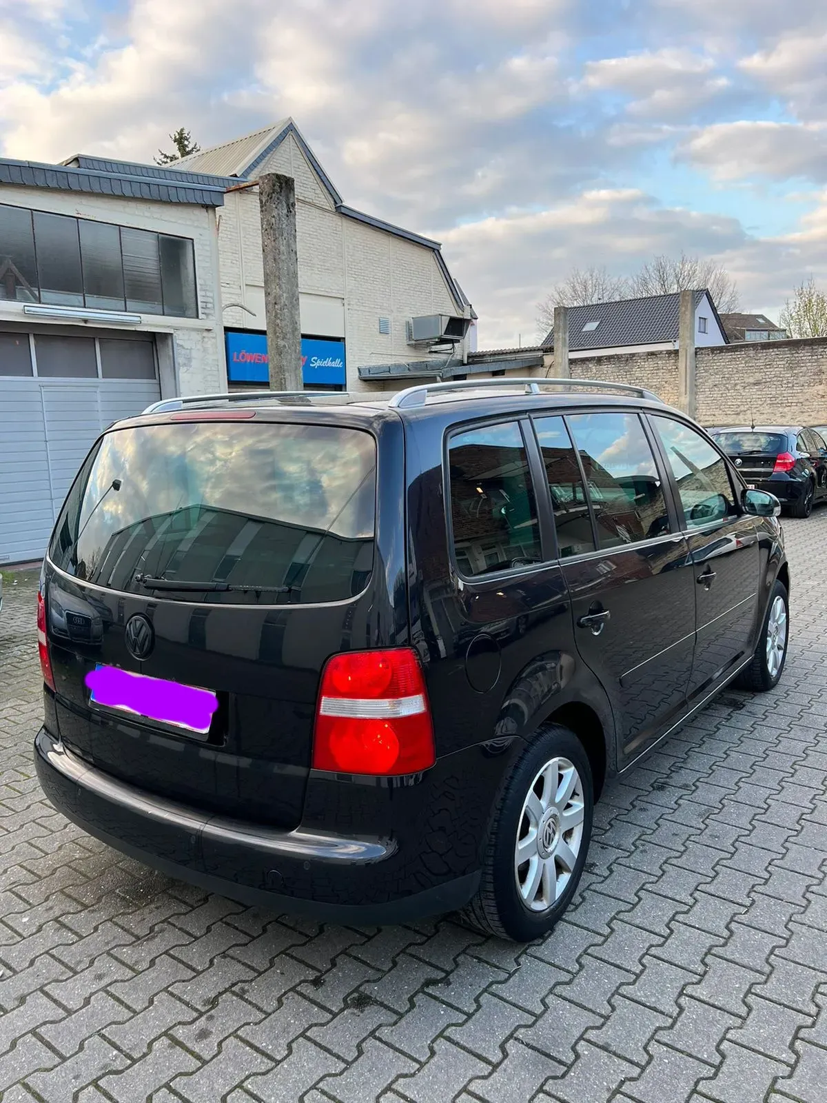 Silberner VW Touran Van von der Fahrerseite