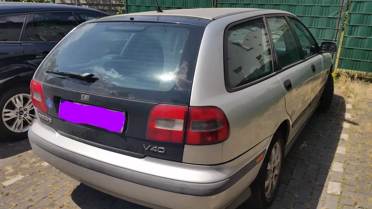 Volvo V40 Silber Kombi Heck Schwarz Rückleuten Teil Beifahrerseite ein 2 Auto steht daneben.