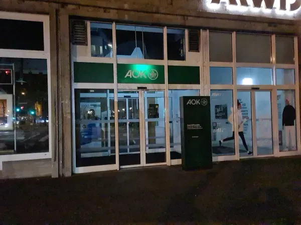 Beleuchteter Eingangsbereich der AOK in Duisburg-Hamborn bei Nacht