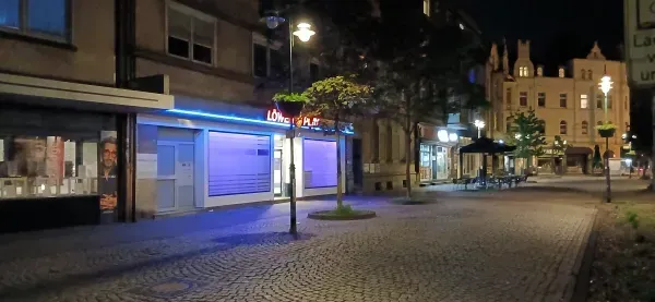 Beleuchtete Geschäfte und Gastronomie in Duisburg-Hamborn bei Nacht.