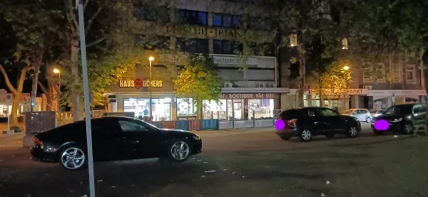 Beleuchtete Geschäfte am Hamborner Marktplatz bei Nacht.