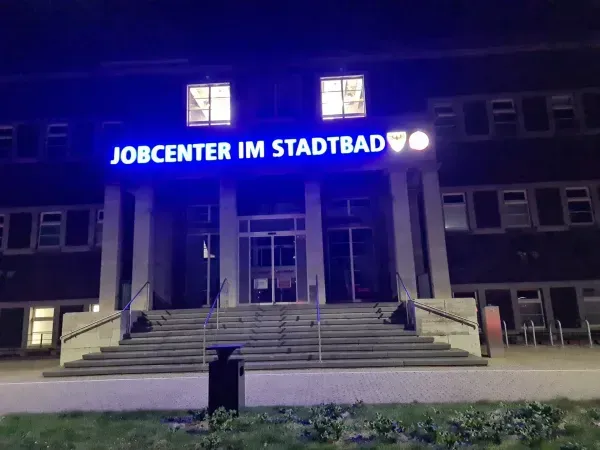 Beleuchteter Eingang vom Jobcenter im Stadtbad Duisburg-Hamborn bei Nacht
