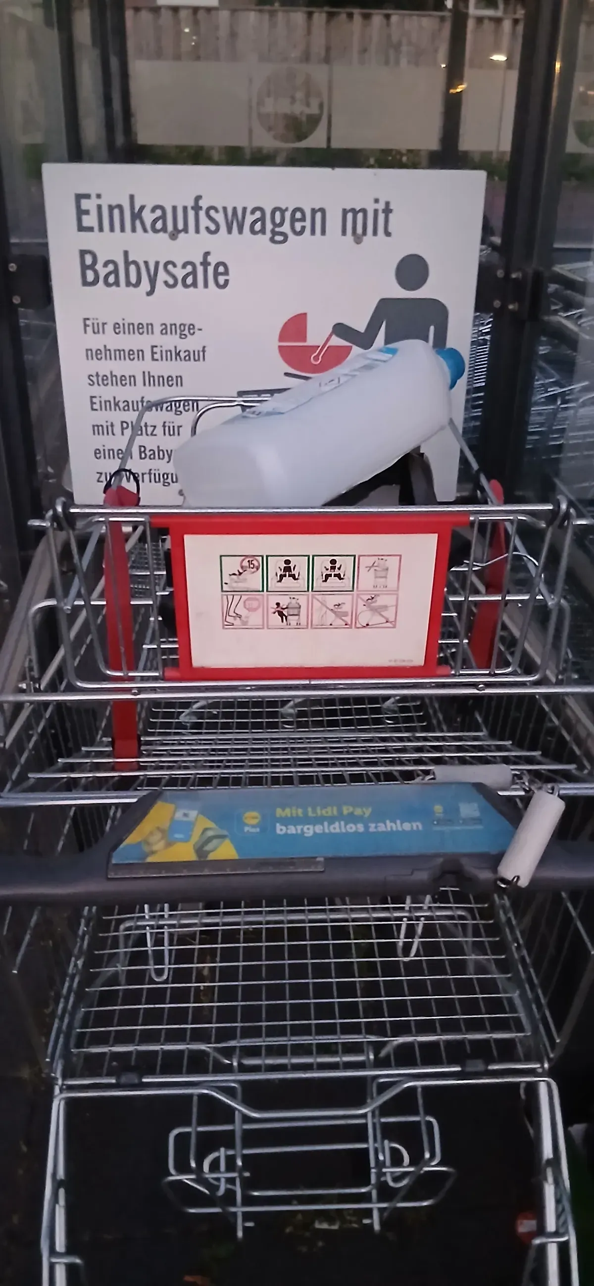 Einkaufswagen mit Babysafe und Abfällen bei Lidl