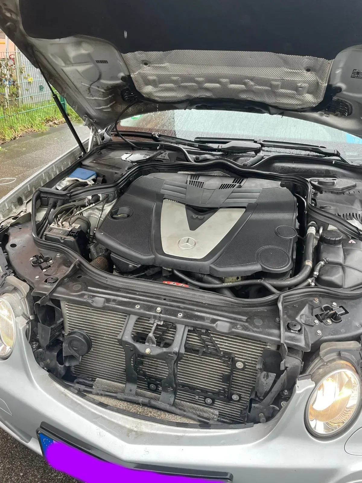 Motorraum eines Mercedes-Benz E 280 CDI T-Modell Baujahr 2008 mit geöffnetem Motorraumdeckel.