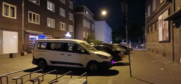 Parkende Autos in einer beleuchteten Seitenstraße in Hamborn bei Nacht.