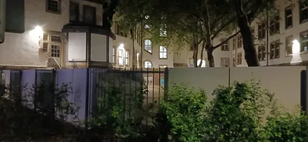 Beleuchtetes Rathausgebäude am Parkplatz in Duisburg-Hamborn bei Nacht.