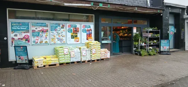 REWE Duisburg-Hamborn am Abend mit Blick auf den Eingangsbereich