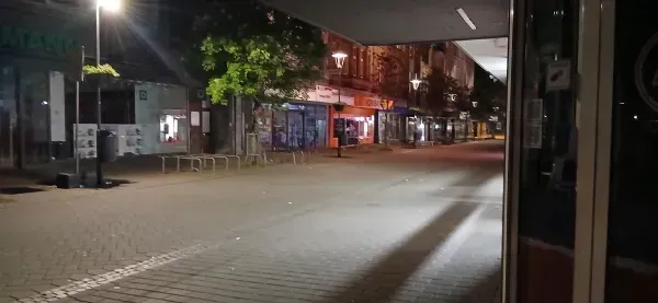 Ruhige, beleuchtete Einkaufsstraße in Duisburg-Hamborn bei Nacht.