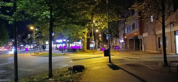 Beleuchtete Straßenkreuzung mit Bäumen in Duisburg-Hamborn bei Nacht.