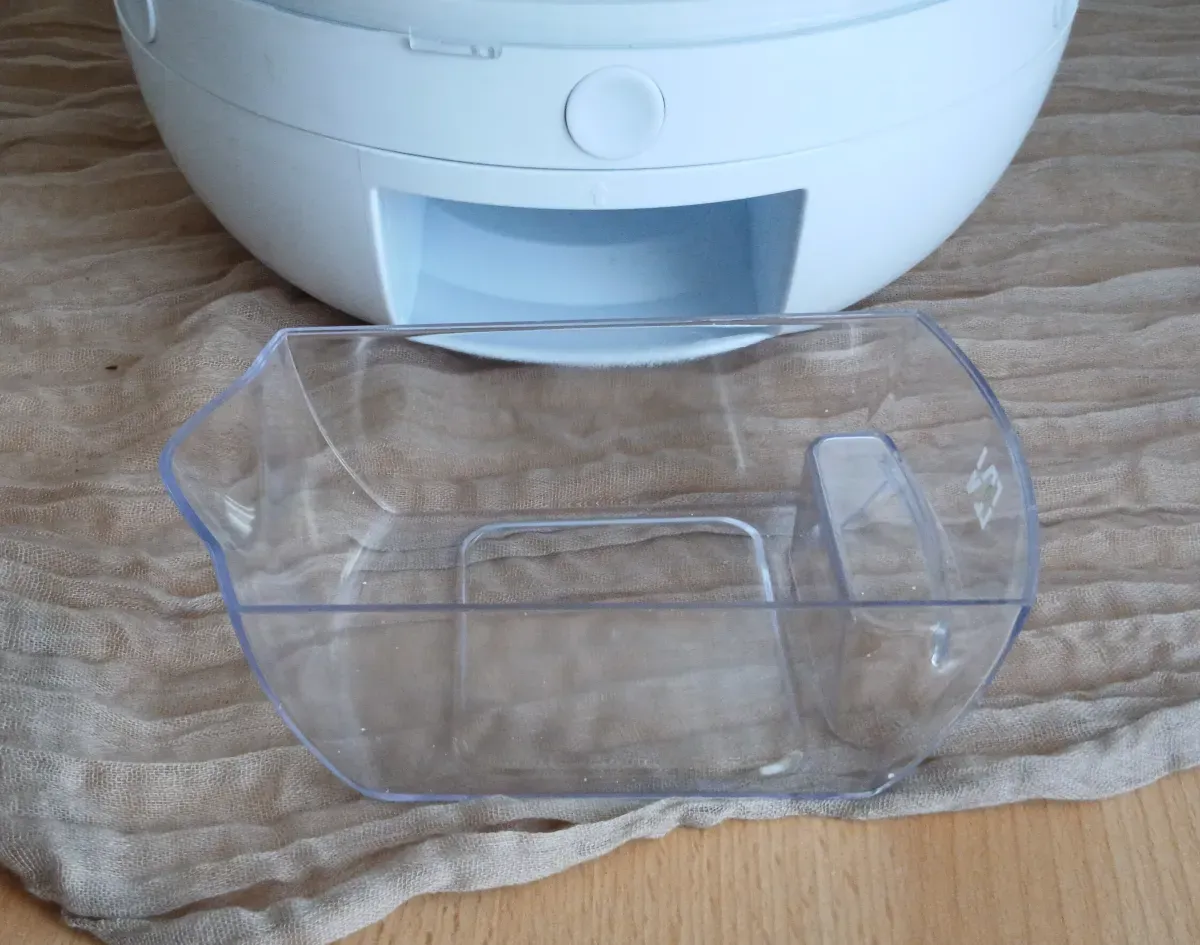 Weiße Vorratsbox mit entnehmbarem transparentem Auffangbehälter vorne