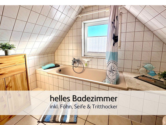 Das helle Badezimmer der FeWo Lütte Krabbe in Bensersiel mit Blick auf die Badewanne und das Fenster