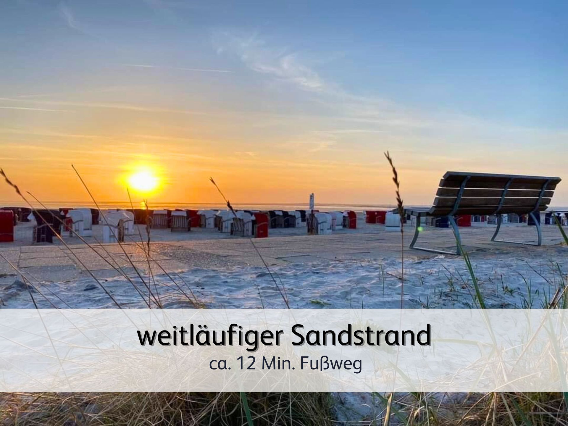Blick auf den Strand von Bensersiel bei Sonnenuntergang. Im Vordergrund ist eine Bank zu sehen. Dahinter sieht man eine Vielzahl von Strandkörben unter der leuchtend orangenen Sonne