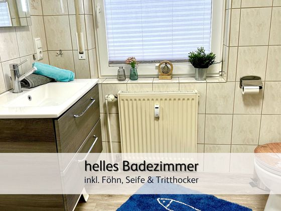 Das helle Badezimmer der FeWo Robbe 2 in Bensersiel mit Blick auf das Waschbecken und das Fenster