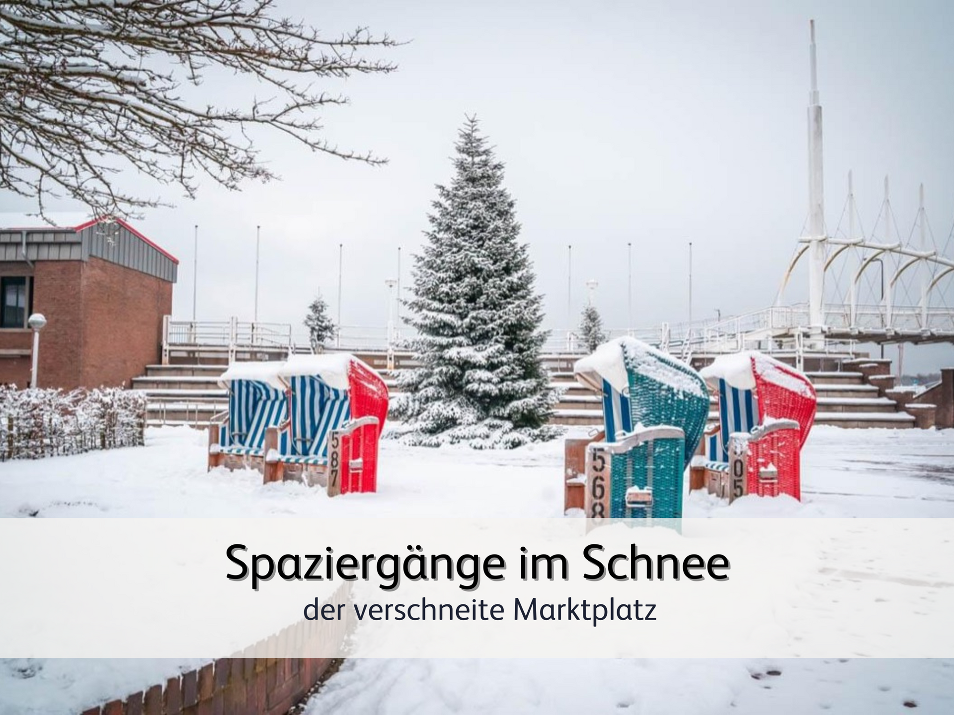 Blick auf den verschneiten Marktplatz von Bensersiel. Im Bild sind verschneite Strandkörbe und ein von Schnee bedeckter Tannenbaum zu sehen