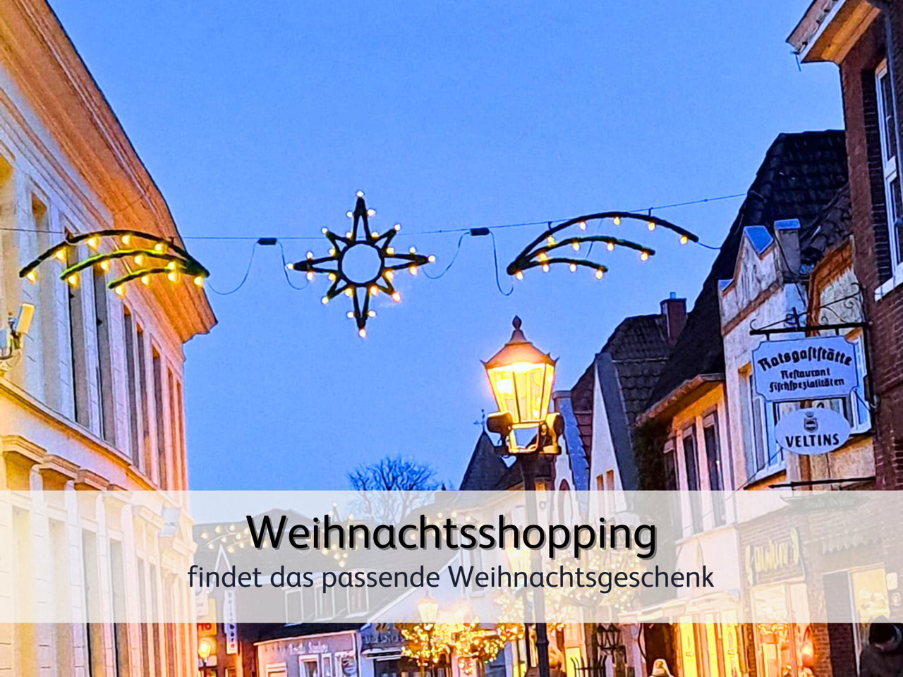 Die weihnachtlich beleuchtete Einkaufsstraße von Esens bei Abenddämmerung 