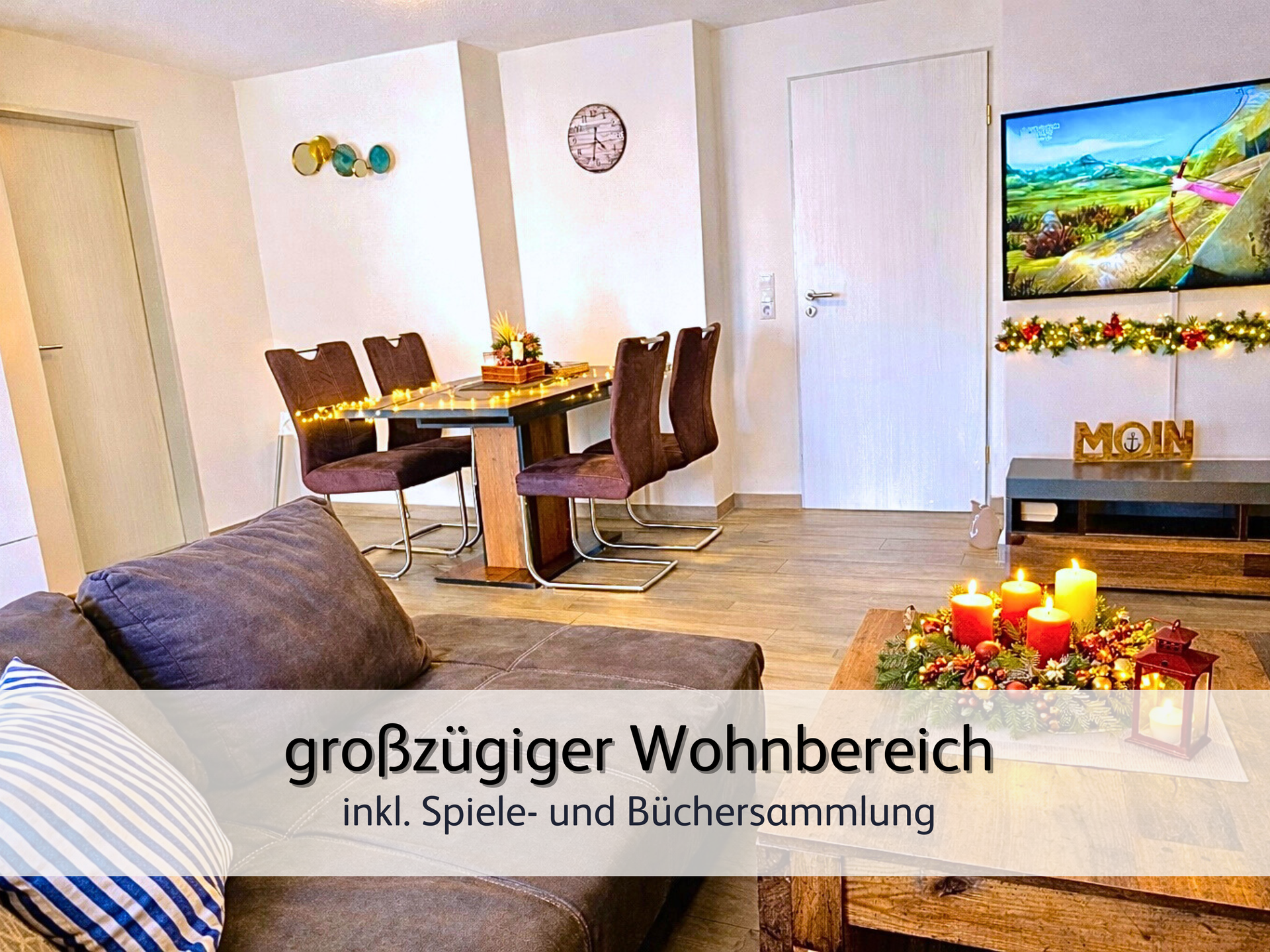 Wohnzimmer der FeWo Robbe 2 in Bensersiel mit Blick in den weihnachtlich geschmückten, warmen Wohnbereich samt Fernseher, Esstisch und 4 Stühlen. Auf dem Esstisch steht ein Adventskranz mit warm leuchtenden Kerzen