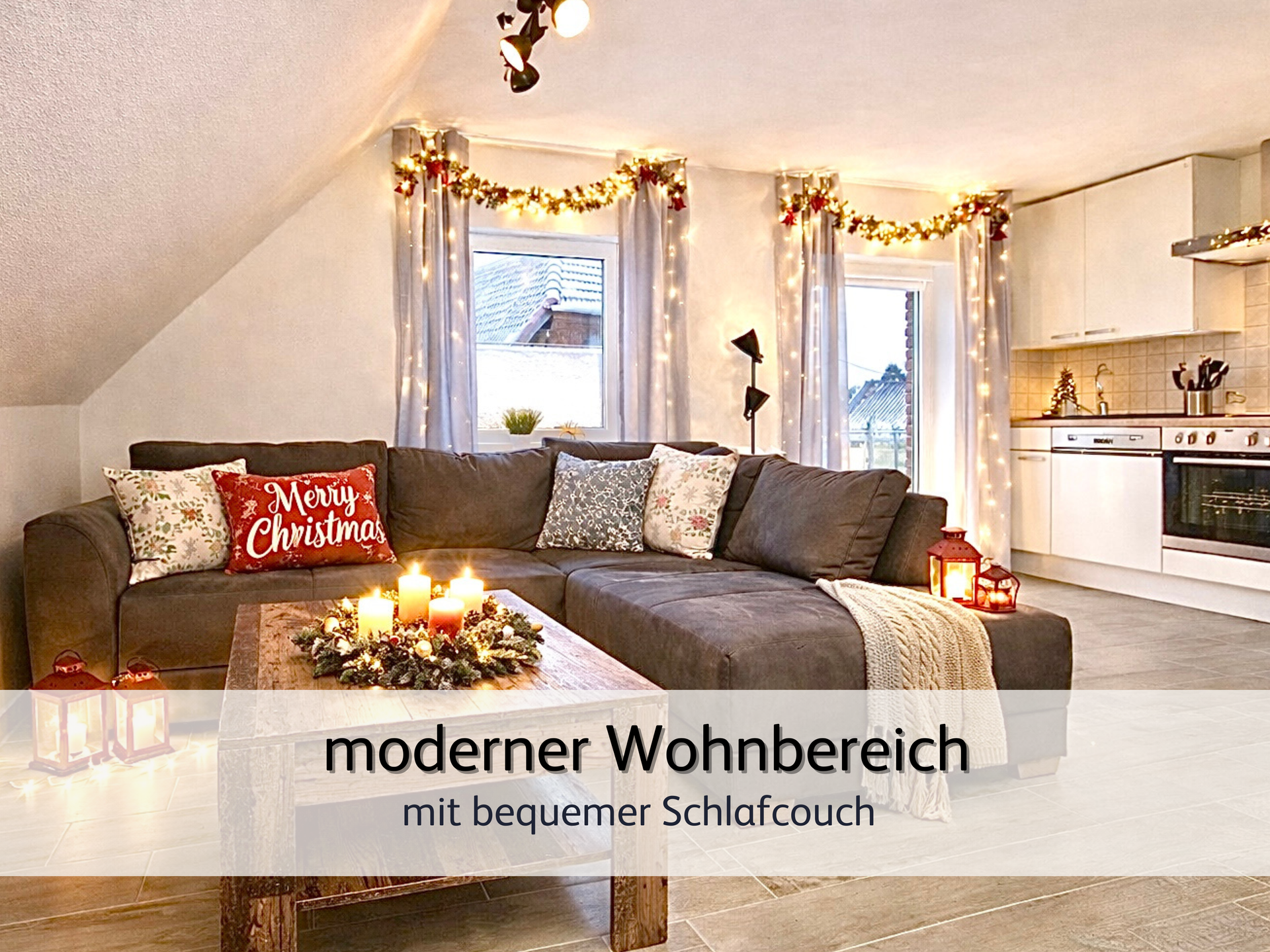 weihnachtlich dekoriertes Wohnzimmer der FeWo Robbe 2 in Bensersiel mit Blick auf das gemütliche Schlafsofa. Im Vordergrund ist ein Couchtisch mit einem Adventskranz und leuchtenden Kerzen. Die Vorhänge vor den Fenstern im Hintergrund sind mit einer Lichtergirlande behangen