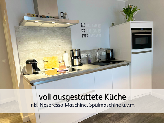 moderne Küchenzeile der Ferienwohnung StrandART in Norddeich mit Kühlschrank, Herd und moderner Arbeitsfläche