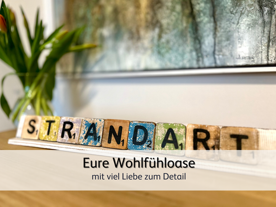 Aus bunten Buchstaben wurde der Name der Ferienwohnung StrandART gelegt – liebevolle Dekoration in der Ferienwohnung StrandART in Norddeich