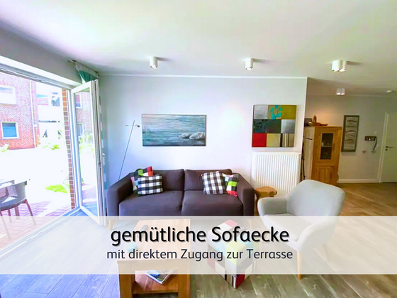 Wohnzimmer der FeWo StrandART in Norddeich mit Blick auf das gemütliche Sofa und der liebevollen Einrichtung