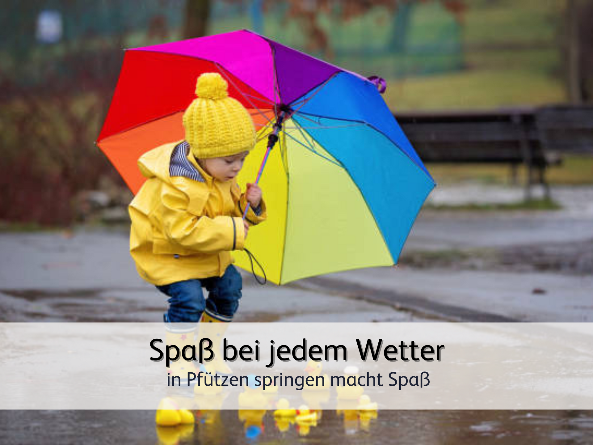 Ein Kind, das mit einer gelben Regenjacke und einem bunten Regenschirm voller Spaß in Pfützen springt