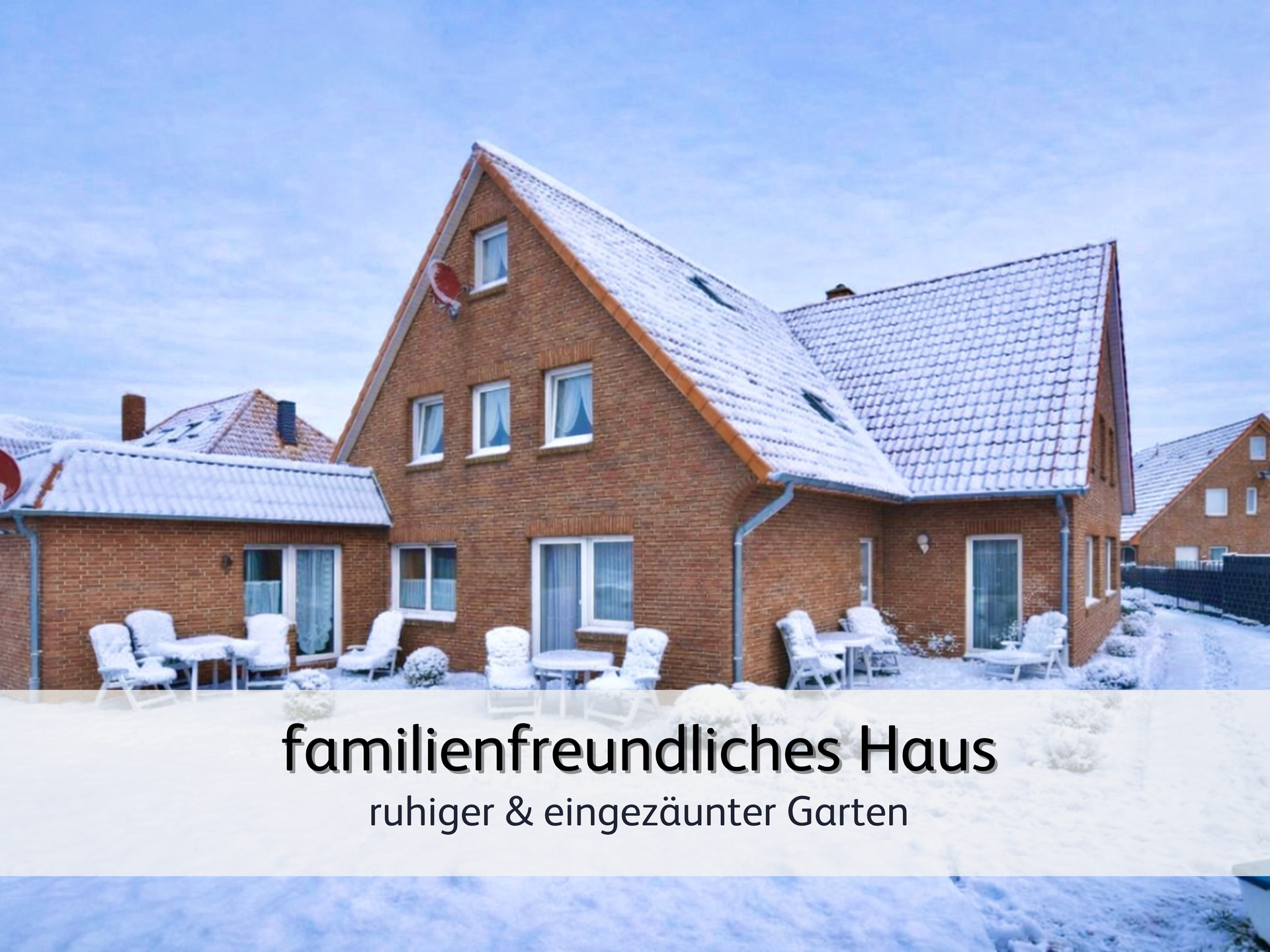 Der verschneite Garten der Ferienwohnung Robbe 2 in Bensersiel bei leicht bewölktem, blauem Himmel. Der Rasen und das Dach sind schneebedeckt
