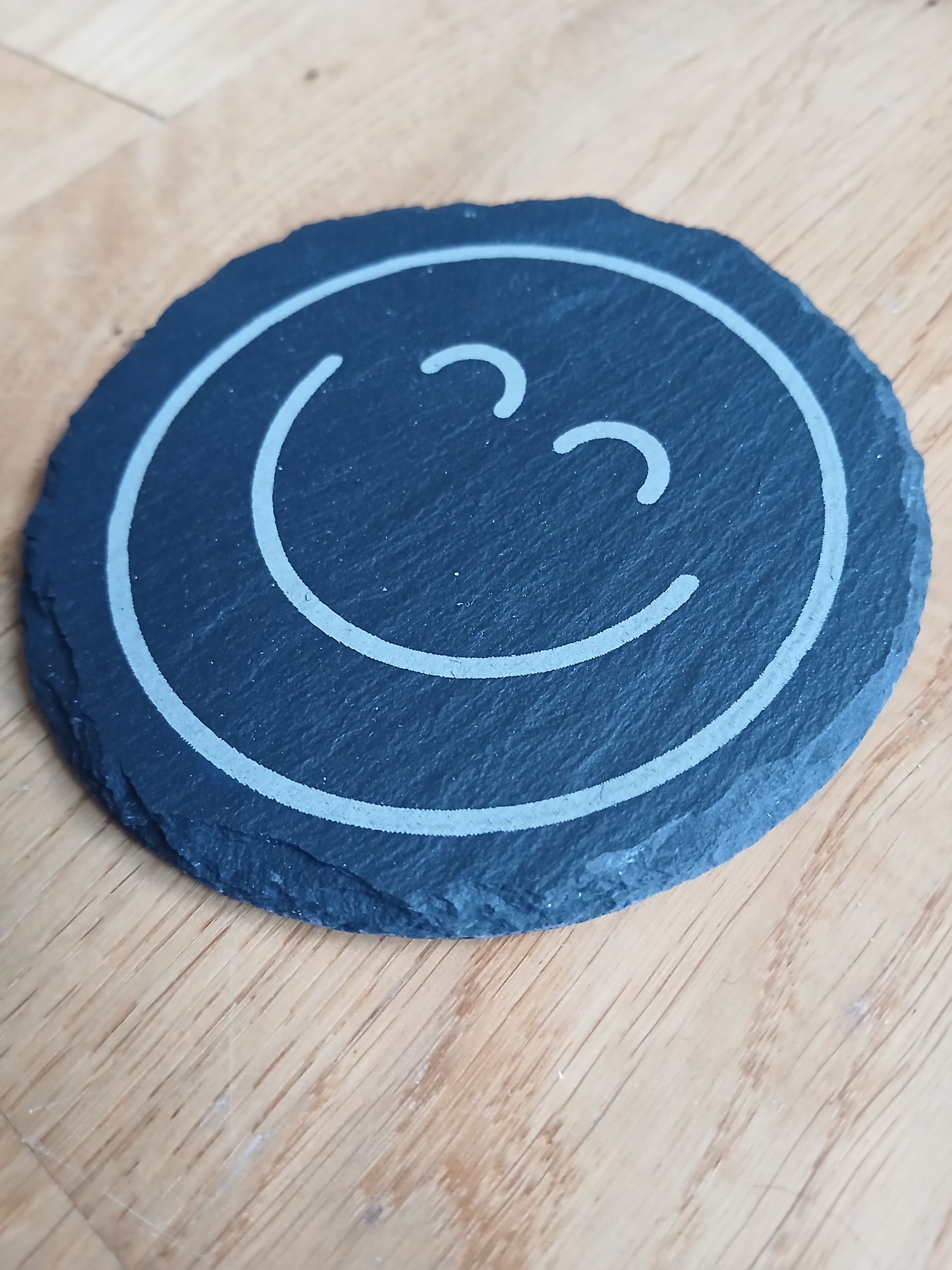 Graviertes rundes Stück Schiefer mit Emoji Smilie 