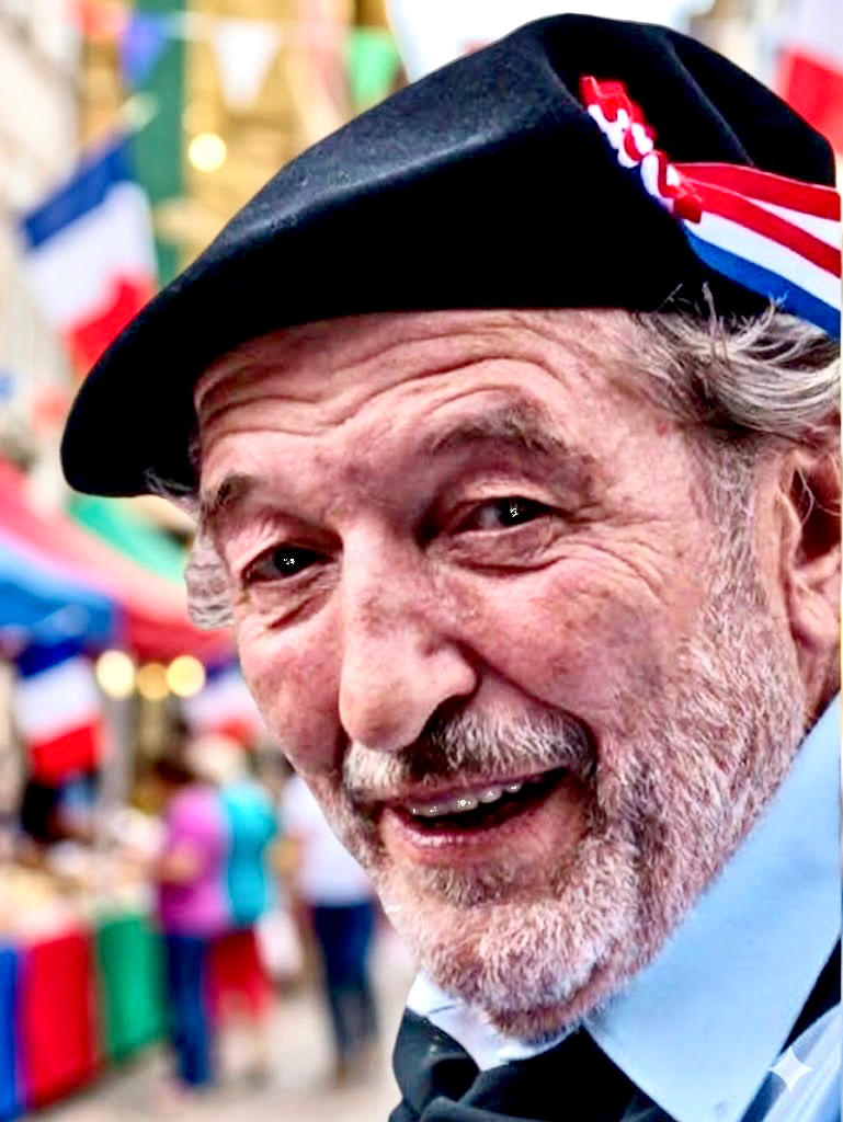 Das Bild zeigt das Porträt eines älteren Herrn mit wachem Blick und einem gewinnenden Lächeln. Er hat schütteres, helles Haar und einen gepflegten grauen Schnurrbart, der seine freundlichen Gesichtszüge unterstreicht. Er trägt ein hellblau gemustertes Hemd unter einer dunklen Weste. Das Foto ist in einem kreisförmigen Ausschnitt gehalten, was den Fokus ganz auf seine positive Ausstrahlung lenkt. Es ist ein Gesicht, das Lebensweisheit und Optimismus ausstrahlt – ein wunderbares Beispiel dafür, wie bereichernd das Miteinander der Generationen in unserem Verein ist.