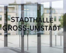 Eingang aus Glas mit schwarzer Aufschrift „STADTHALLE GROSS-UMSTADT“