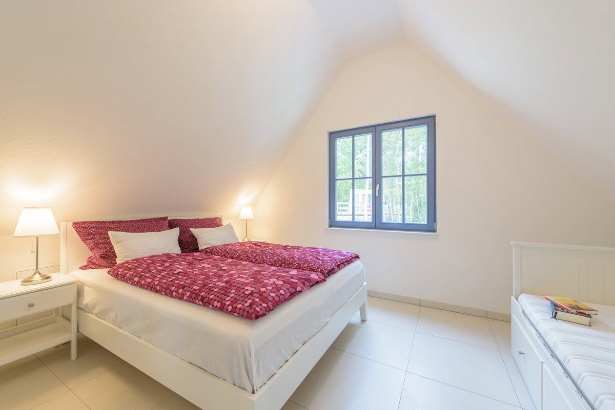 Schlafzimmer mit einen Doppelbett und einem Einzelbett im Ferienhaus Eulenenst in Glowe