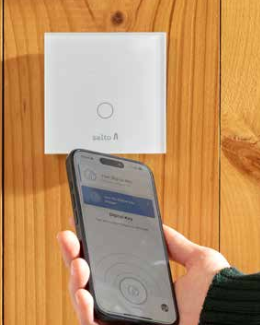 Bild von SALTO Wandleser mit Handy um zu signalisieren, dass Wandleser und Handyöffnungen im Hotelbereich abgebildet werden können.