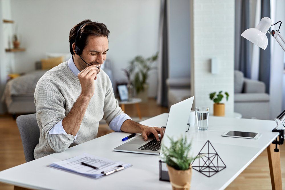 man working on computer wiht headset