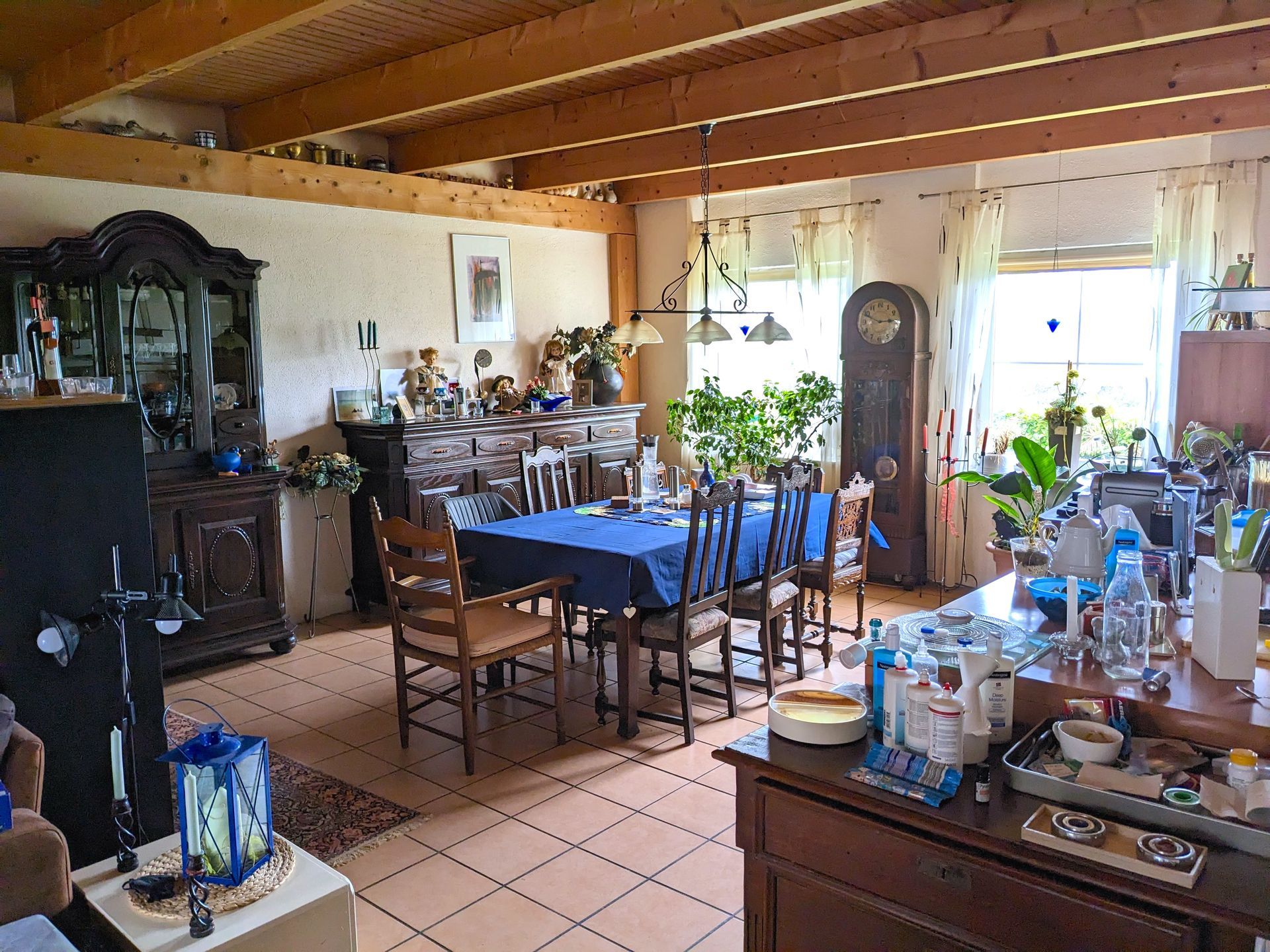 Geräumiges Esszimmer mit Holzdecke, gedecktem Tisch und antiken Möbeln.