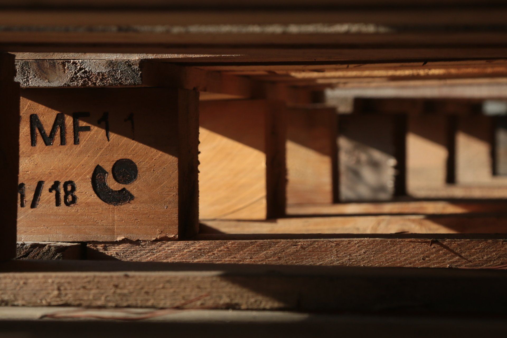 Close-up of wooden pallets lit by evening sun by Joanna Urwin, photographer