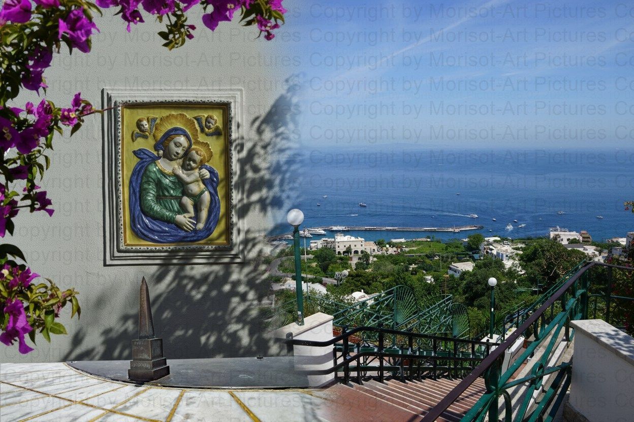 Religiöse Fliesenbilder an einer mit Bougainvillea bewachsenen Wand mit Blick auf das Meer und eine sonnige Landschaft.