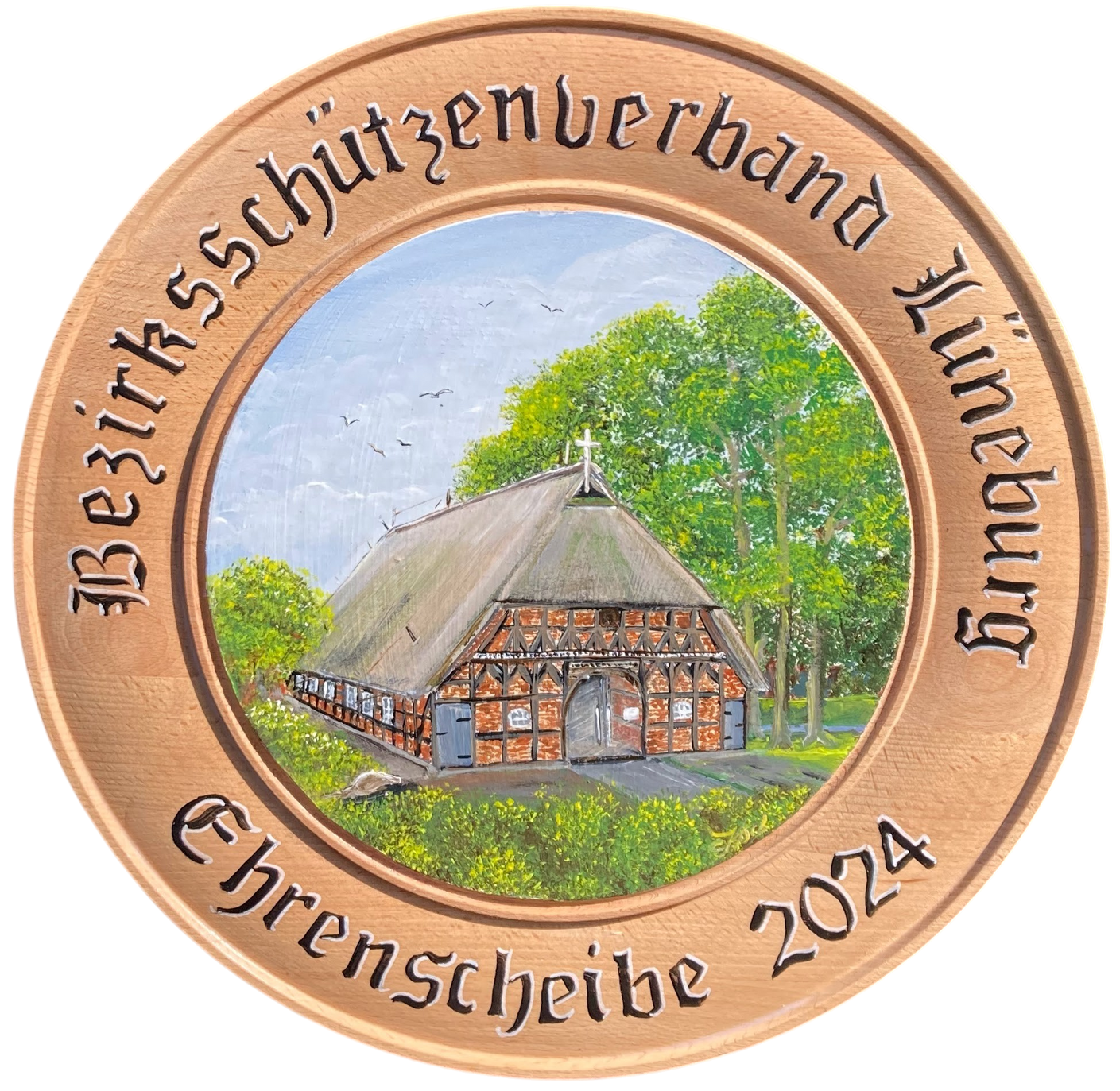 Handbemalte hölzerne Ehrenscheibe des Bezirksschützenverbandes Lüneburg 2024 mit dem Motiv der Martinuskirche in Deutsch Evern, einer historischen Fachwerkscheune mit Reetdach
