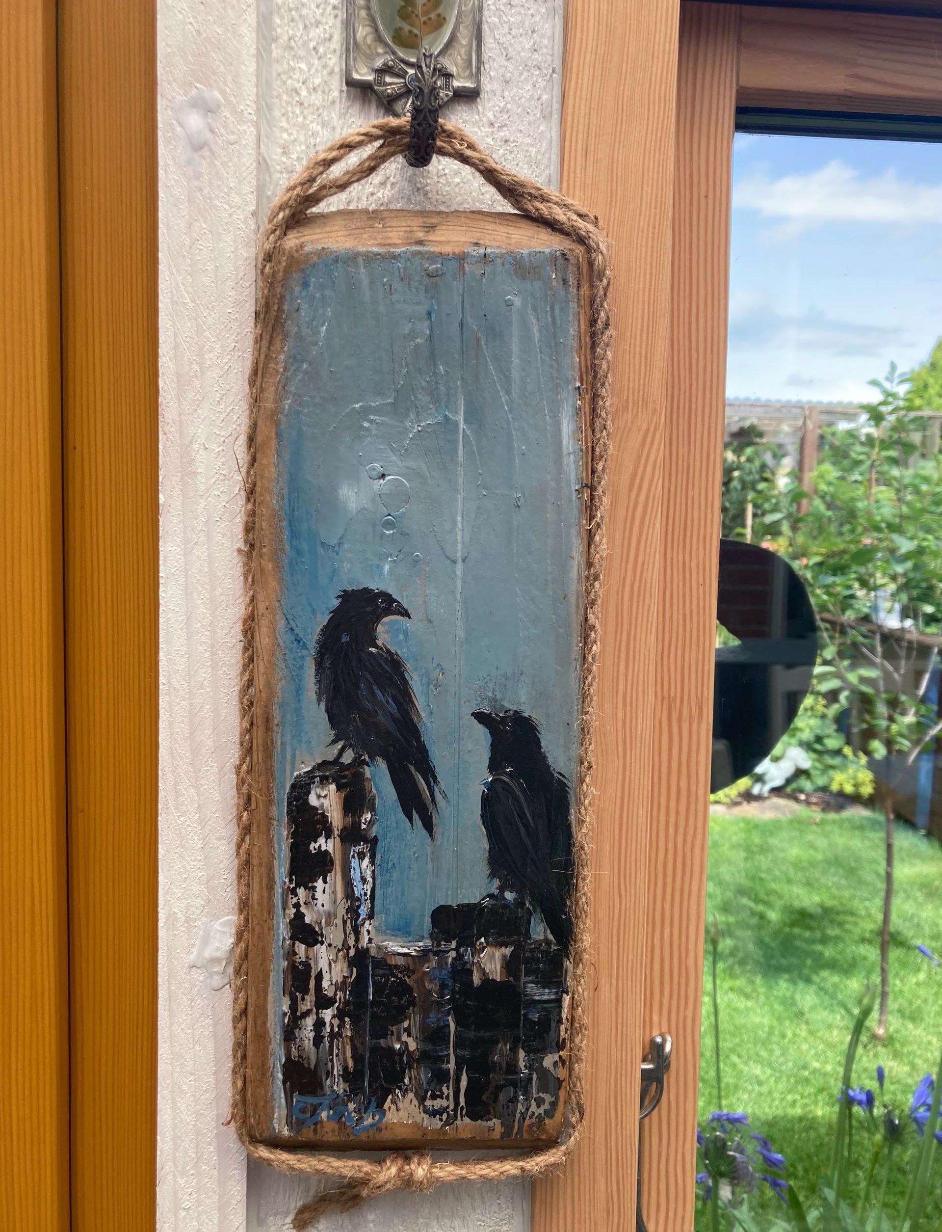 Zwei Krähen handgemalt auf einem Treibholzbrett aus den Salzwiesen in Dornumersiel