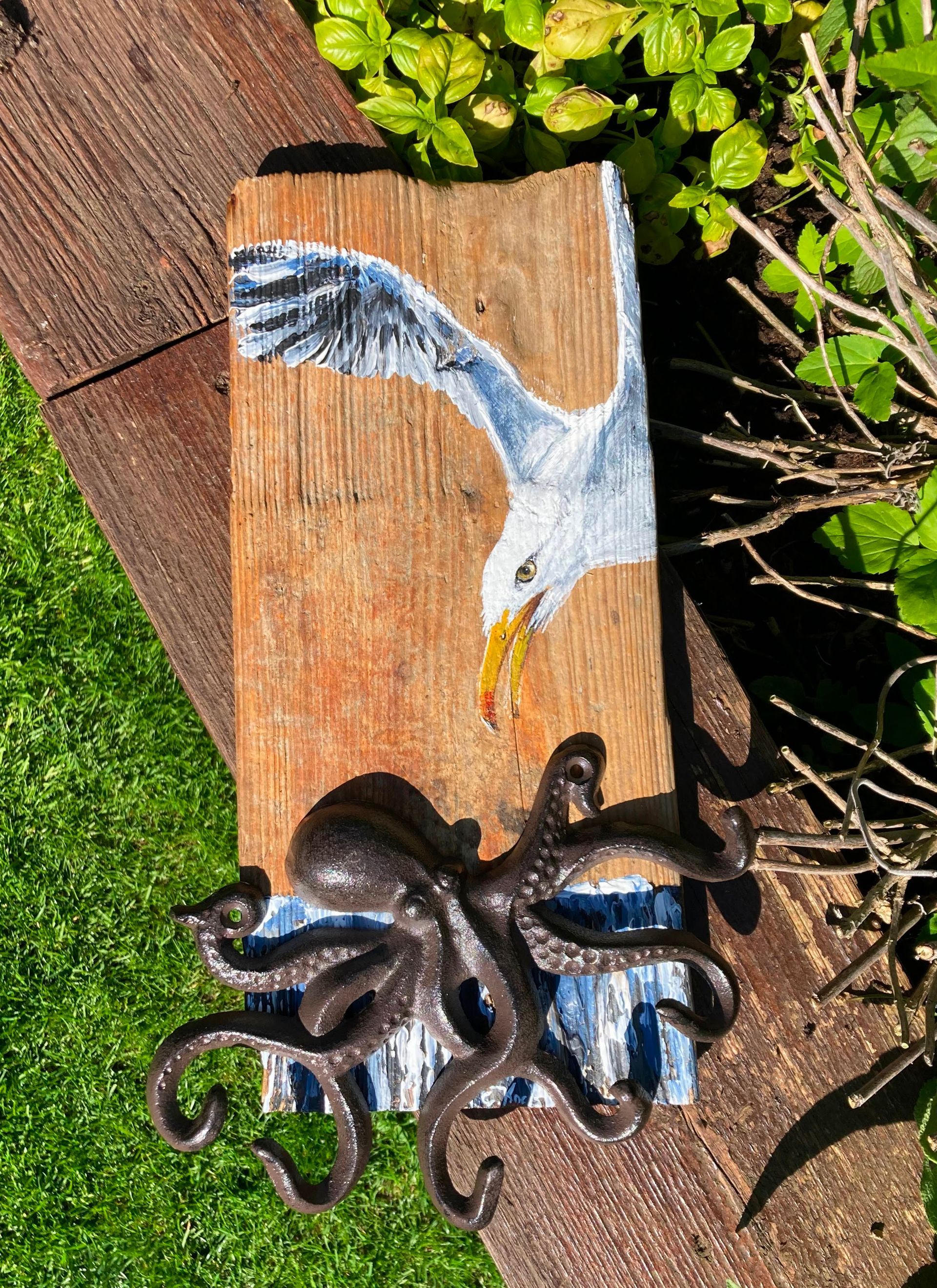 Treibholz bemalt mit einer Möwe. Unten ein Krake aus Gußeisen als Schlüsselbord. Vorschau-Mühlenmarkt-Trittau -23.05.2026-25.05.2026-Atelier-am-Deich