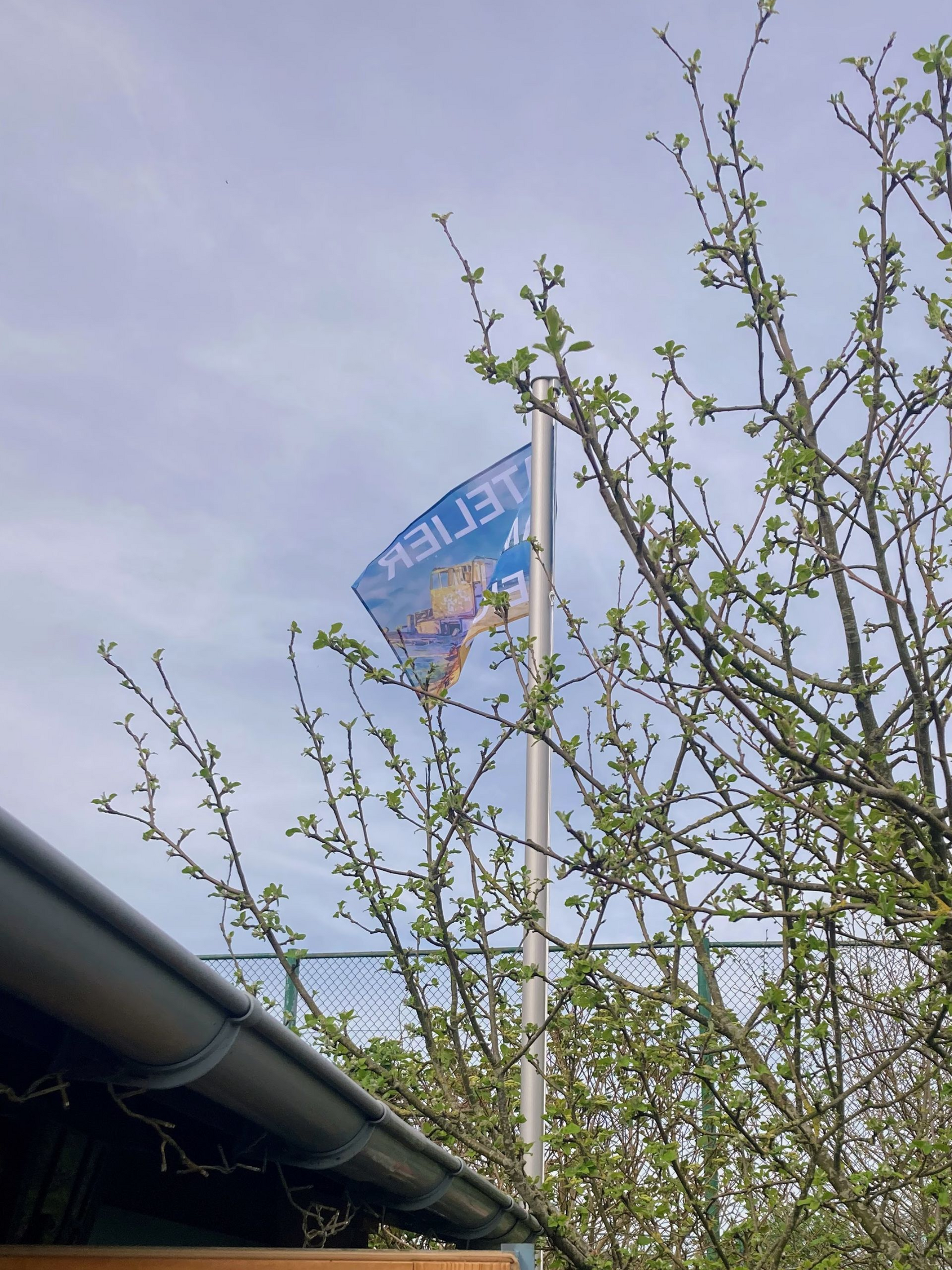 Offenes Garten-Atelier am Deich in Dornum: Gehisste Fahne am Mast als Einladung für Besucher bei Claudia Koch.