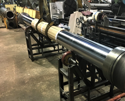 Large chrome plated hydraulic piston rod waiting to be assembled