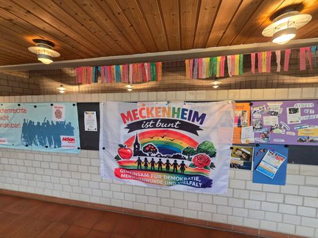 Bannerpräsentation beim Meckenheimer Festspiel mit bunten Plakaten an einer gefliesten Wand unter einer Holzdecke