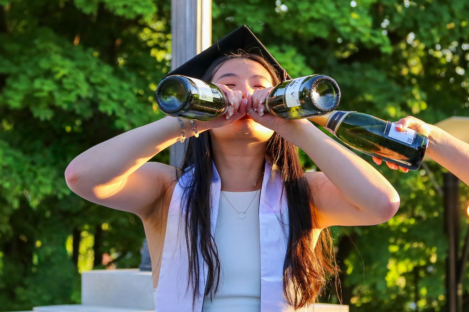Champagne pop graduation portraits during sunset