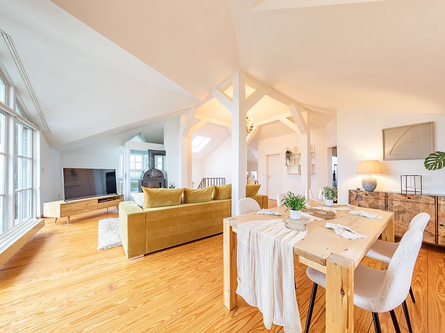 Heller Essbereich im Dachgeschoss mit Holztisch und Blick ins Grüne im Home Staging
