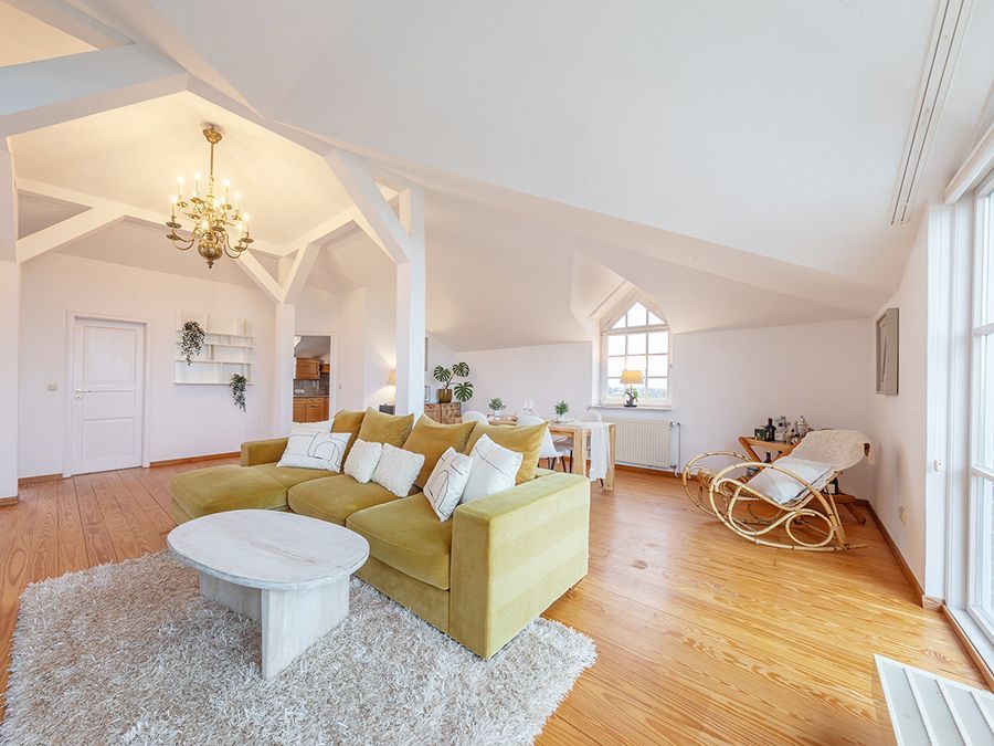 Offener Wohnbereich im Dachgeschoss mit gelbem Sofa und viel Licht im Home Staging Hamburg