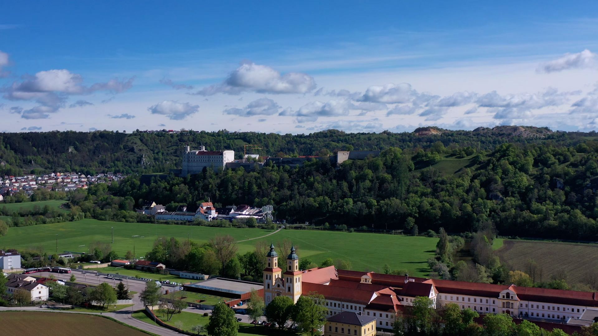 Blick über das Altmühltal mit seinen grünen Wiesen und den historischen Gebäuden Eichstätts.